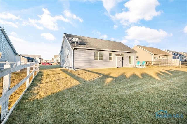 rear view of house featuring a lawn