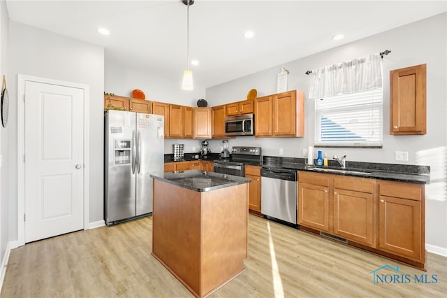 kitchen featuring sink, light hardwood / wood-style flooring, hanging light fixtures, stainless steel appliances, and a kitchen island