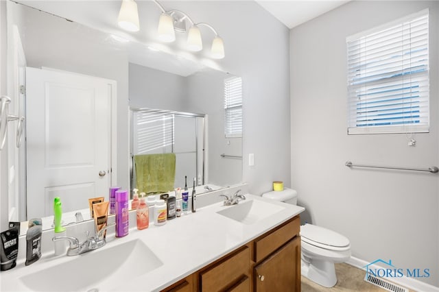 bathroom with vanity, an enclosed shower, and toilet