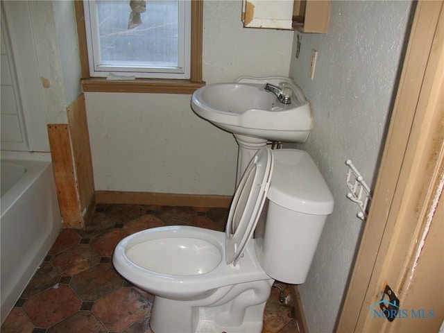 bathroom with a tub and toilet