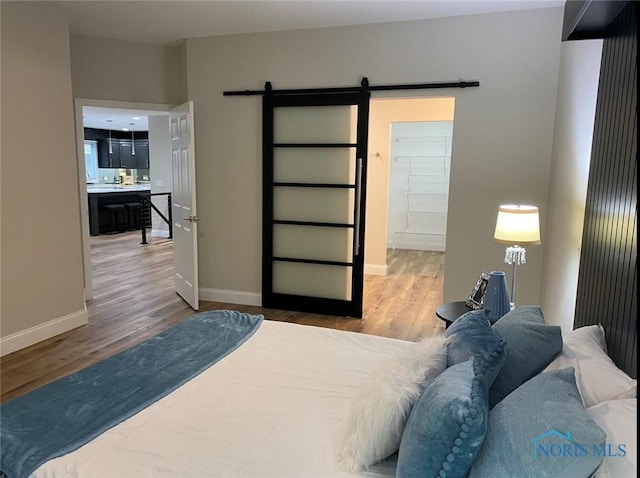 bedroom with hardwood / wood-style flooring and a barn door