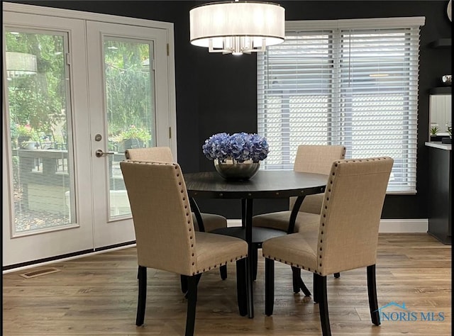 dining space with french doors and wood-type flooring