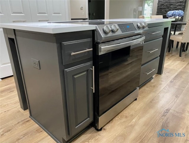 kitchen featuring a center island, light hardwood / wood-style flooring, and electric range