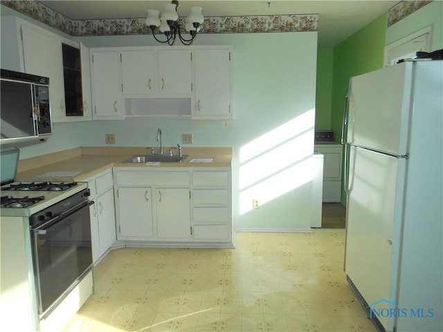 kitchen with washer / dryer, sink, white cabinets, and white appliances