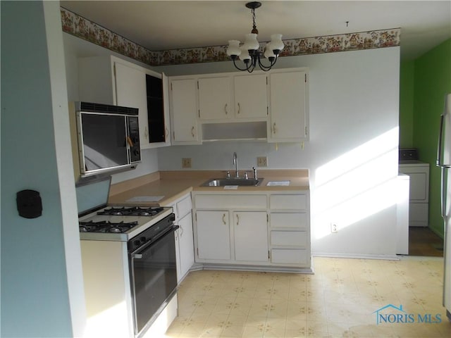 kitchen featuring pendant lighting, sink, white gas range oven, and white cabinets