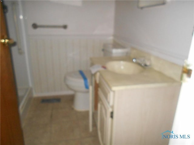 bathroom with vanity, toilet, and a shower