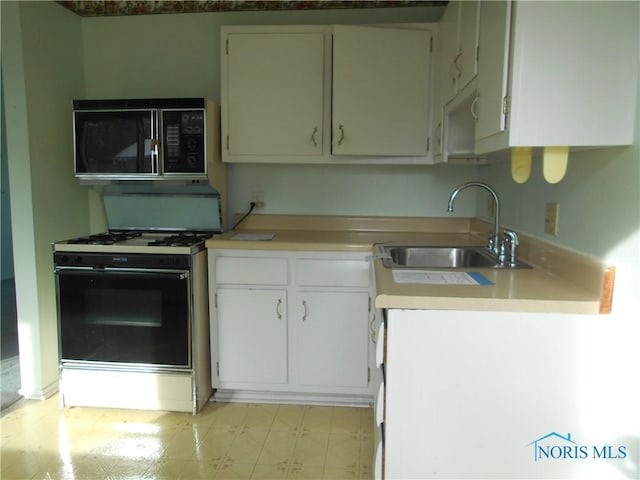 kitchen with gas stove, sink, and white cabinets