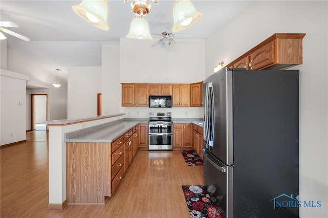 kitchen with ceiling fan, stainless steel appliances, kitchen peninsula, and hanging light fixtures