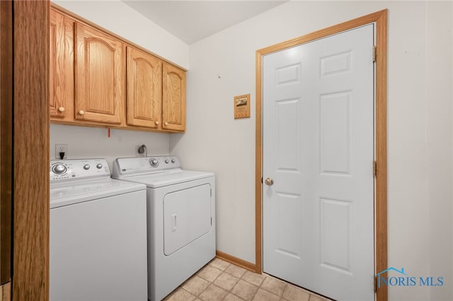 clothes washing area featuring cabinets and independent washer and dryer