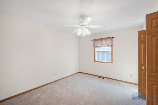 spare room with light colored carpet and ceiling fan