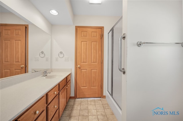 bathroom with a shower with door and vanity