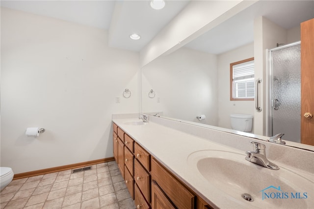 bathroom with vanity, a shower with door, and toilet