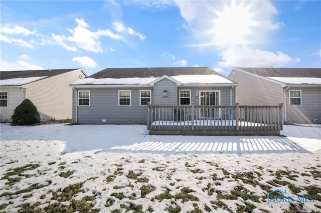 snow covered house featuring a wooden deck