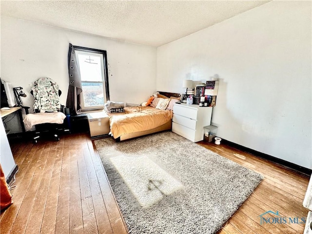 bedroom featuring hardwood / wood-style flooring and a textured ceiling