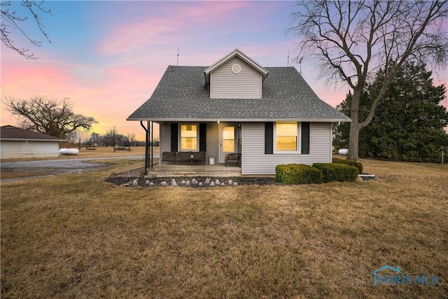 view of front of property with a porch and a yard