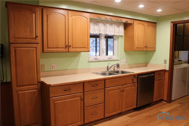 kitchen featuring dishwasher, separate washer and dryer, sink, and light hardwood / wood-style floors