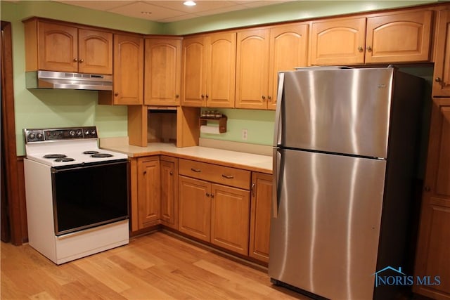 kitchen featuring electric stove, stainless steel fridge, and light wood-type flooring