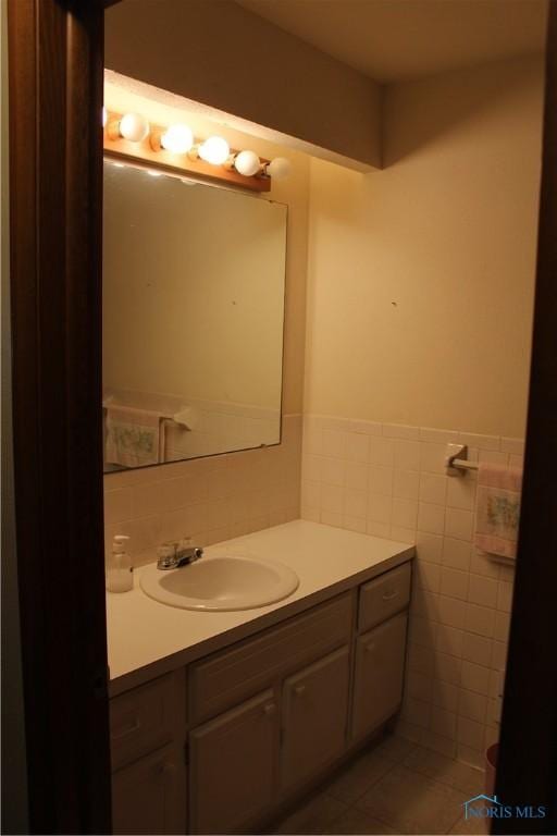 bathroom with tile patterned flooring, vanity, and tile walls