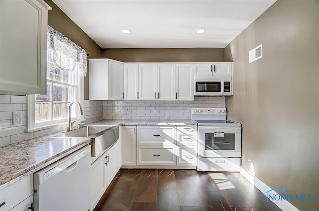 kitchen with sink, white cabinets, and white appliances