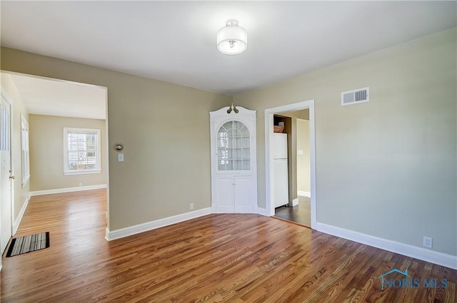 empty room with hardwood / wood-style flooring