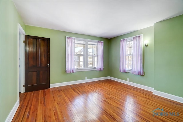 unfurnished room with hardwood / wood-style floors