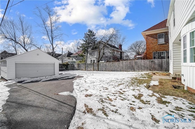 snowy yard with an outbuilding and a garage