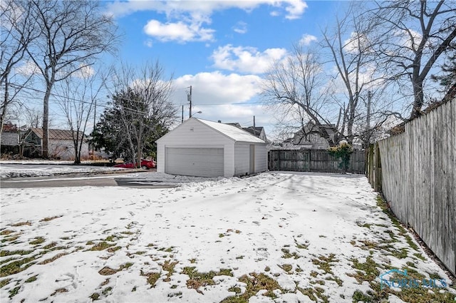 yard covered in snow with a garage and an outdoor structure