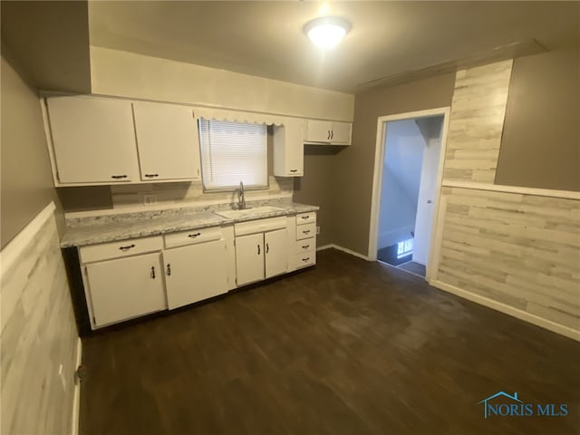 kitchen featuring white cabinetry, sink, light stone counters, and dark hardwood / wood-style flooring