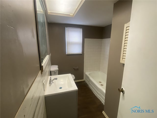 bathroom featuring vanity, a washtub, and toilet