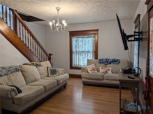 living room with hardwood / wood-style flooring, a chandelier, and a textured ceiling