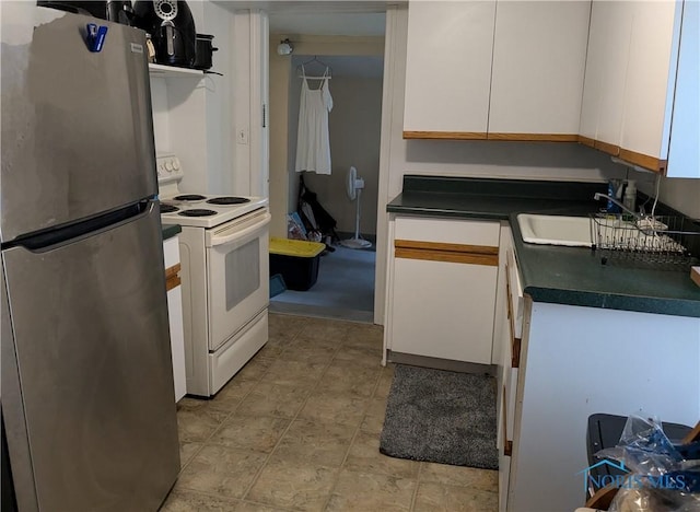 kitchen featuring sink, stainless steel fridge, white cabinets, and white range with electric stovetop