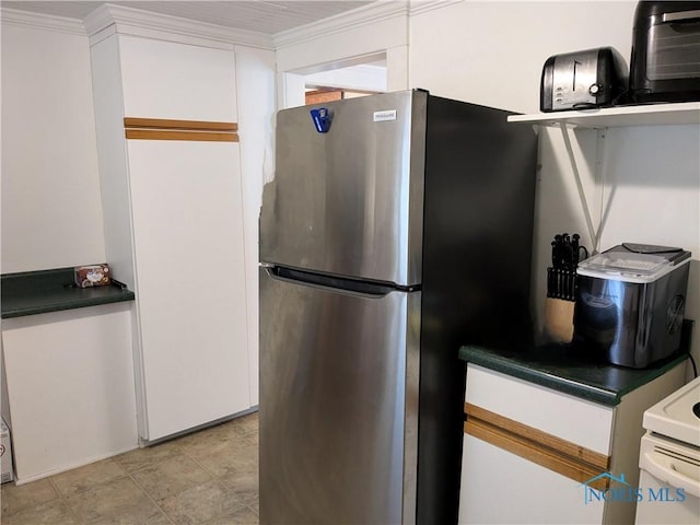 kitchen with stainless steel fridge, ornamental molding, and white cabinets