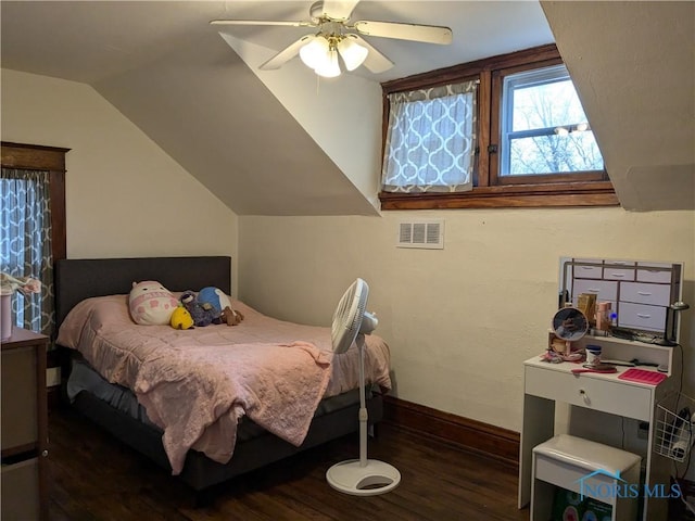 bedroom featuring dark hardwood / wood-style flooring, lofted ceiling, and ceiling fan