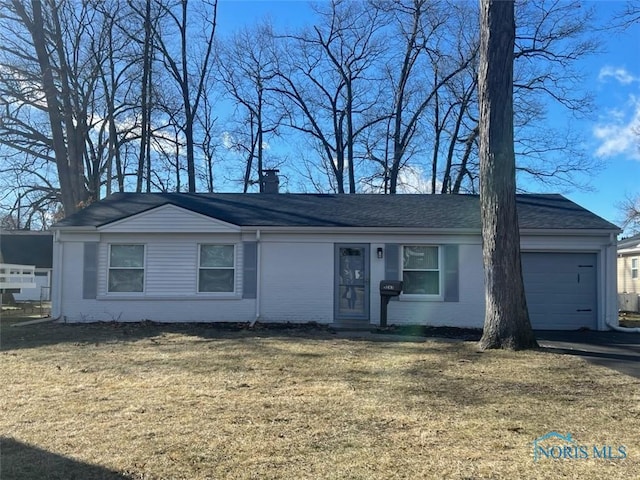 single story home featuring a garage and a front lawn