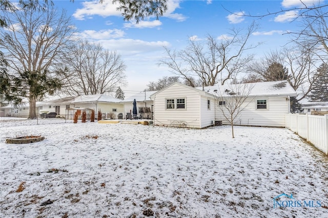 view of snow covered back of property