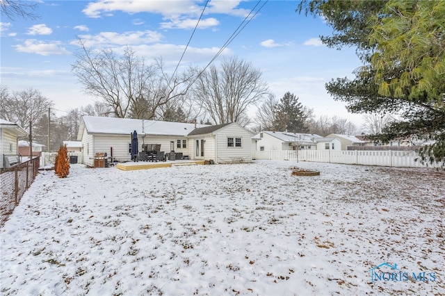 snow covered house with a deck