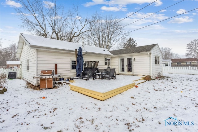 snow covered rear of property with french doors