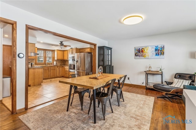 dining room with sink, ceiling fan, and light hardwood / wood-style flooring