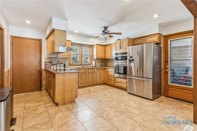 kitchen featuring sink, ceiling fan, appliances with stainless steel finishes, light stone counters, and decorative backsplash