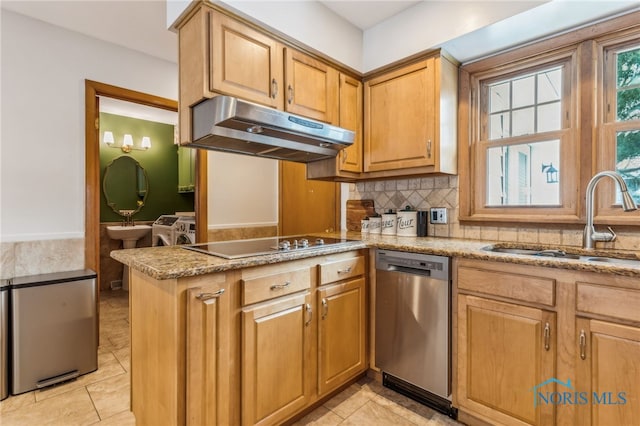 kitchen featuring sink, stainless steel appliances, washing machine and dryer, decorative backsplash, and kitchen peninsula