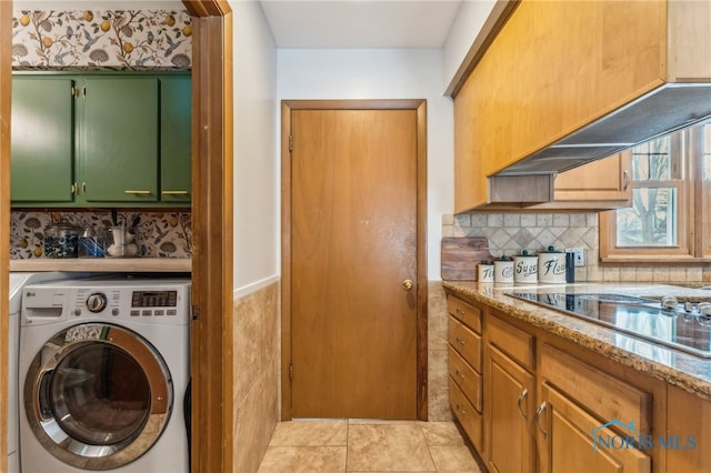 clothes washing area featuring cabinets, light tile patterned flooring, and washer / dryer