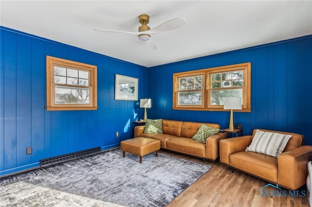 living room featuring hardwood / wood-style flooring, ceiling fan, a baseboard heating unit, and a wealth of natural light