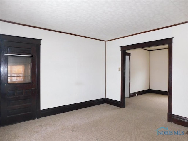 carpeted empty room with ornamental molding and a textured ceiling