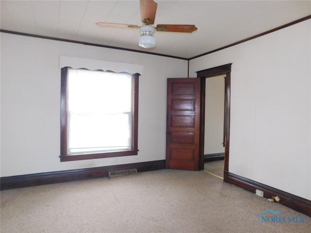 carpeted spare room featuring ornamental molding and ceiling fan