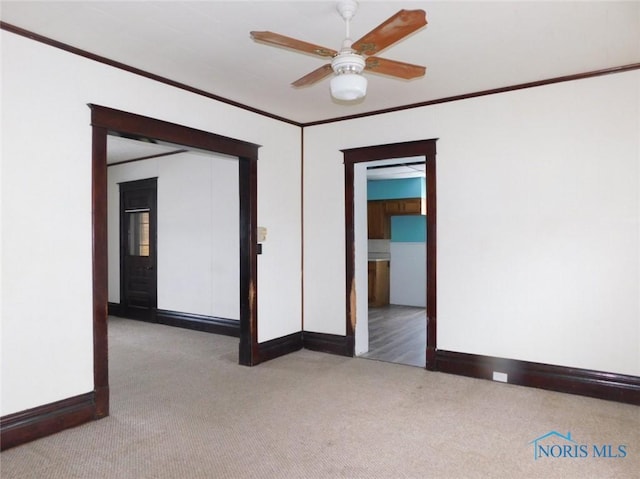 carpeted empty room with crown molding and ceiling fan