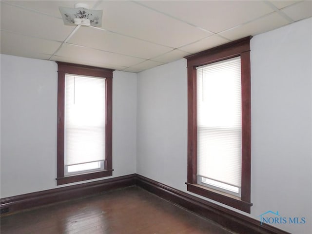 spare room featuring a paneled ceiling and hardwood / wood-style floors