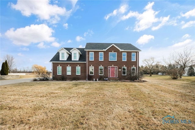 colonial house featuring a front lawn