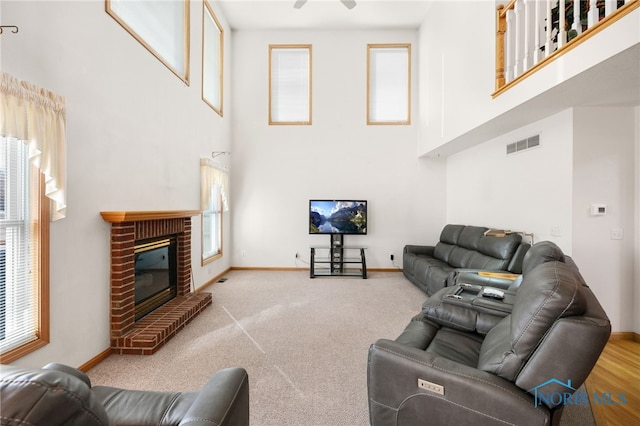 living room with a fireplace, a wealth of natural light, and a high ceiling