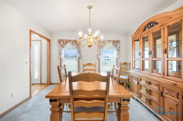 dining area featuring light carpet and a notable chandelier