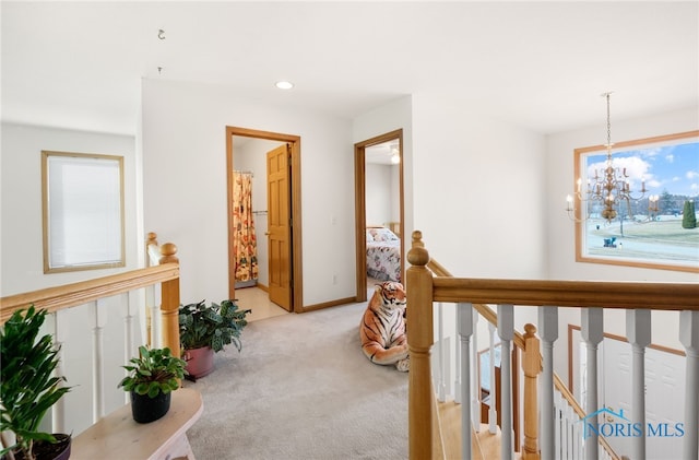 corridor featuring light colored carpet and a notable chandelier